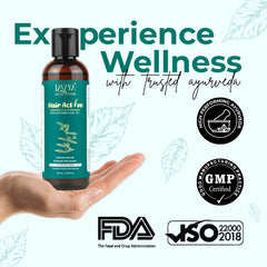 Bottle of 'Hair Active Oil' held in a hand with certification logos and text on a light green background