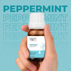 Hand holding a bottle of Lavera Tea Tree essential oil against a blue background with 'Tea Tree' text.