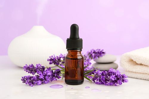 Amber dropper bottle of lavender essential oil with fresh lavender flowers and spa accessories