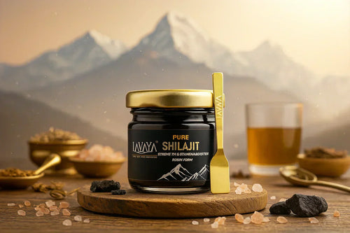 Product shot of Lavaya Pure Shilajit jar with gold spoon on wooden board, shilajit pieces, and Himalayan salt crystals, with mountain background.
